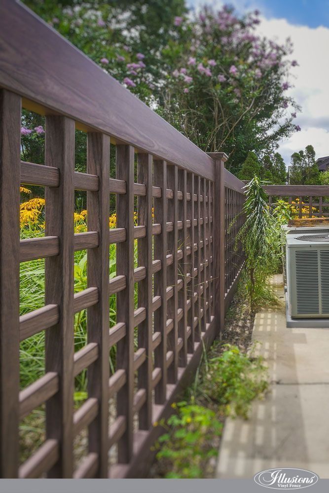 Brown lattice fence outdoors with plants and an air conditioning unit.